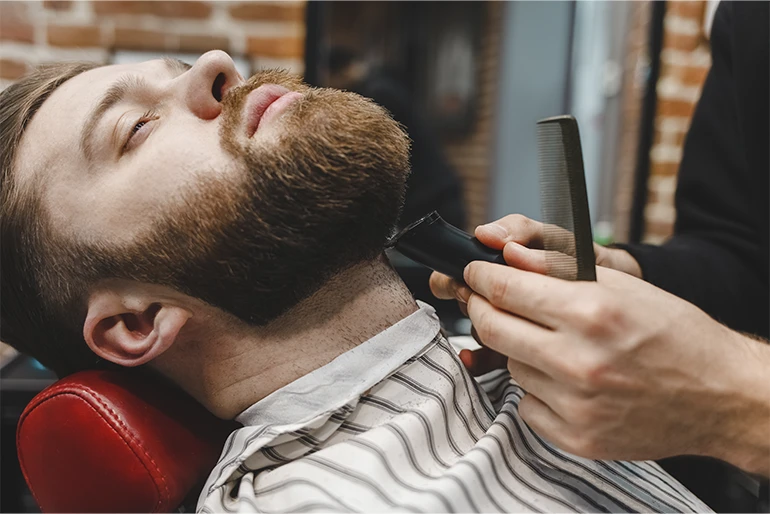 Cuidado de la barba de un hombre en una barbería